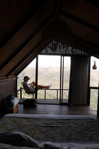 a man sitting in a chair in a room with a window at REFUGIO LA ROCA in Los Santos