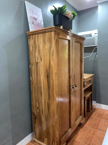 a wooden cabinet with a potted plant on top at Lovely Bedroom in Lila, Bohol with WIFI, AC and Ref in Lila