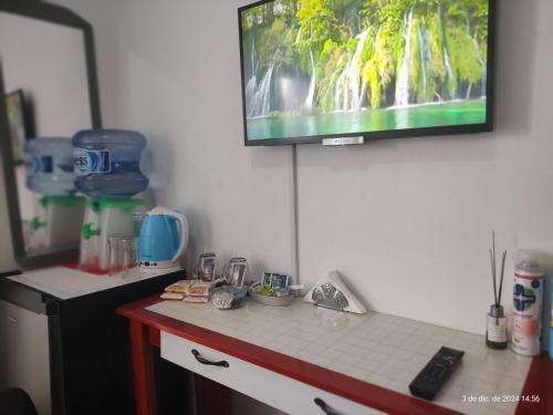 a kitchen with a counter with a tv on the wall at HOSTAL , Habitación en vivienda familiar in Buenos Aires