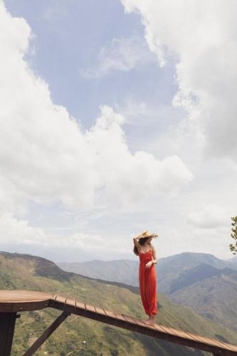 a woman in a red dress standing on top of a mountain at REFUGIO LA ROCA in Los Santos