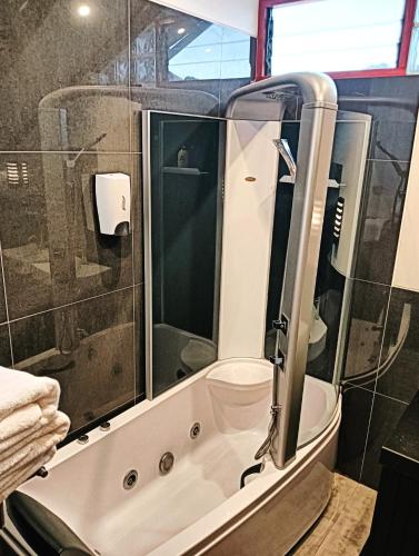 a bathroom with a shower and a tub with a sink at Illa B&B in Cusco