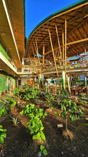 a building with a bunch of plants in a garden at Bonding Coffee Roaster Café & Hotel in Quepos