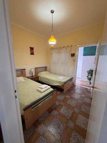 a bedroom with two beds and a pendant light at La Casa de la Nona Elisa in Mar del Plata