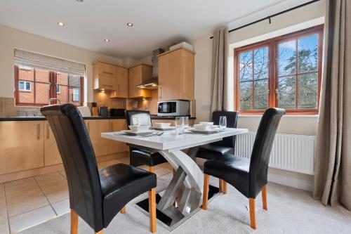 a kitchen and dining room with a table and chairs at Cozy 2bed flat with free parking near Willen Lake in Milton Keynes in Milton Keynes