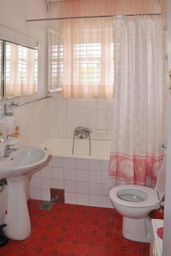 a bathroom with a toilet and a tub and a sink at Apartments Boris in Orebić