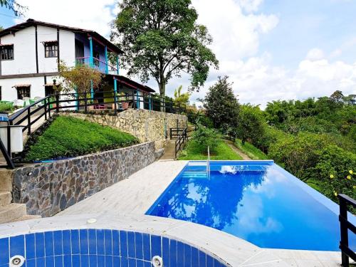 a swimming pool in front of a house at Iraka Campestre Quindio in El Edén