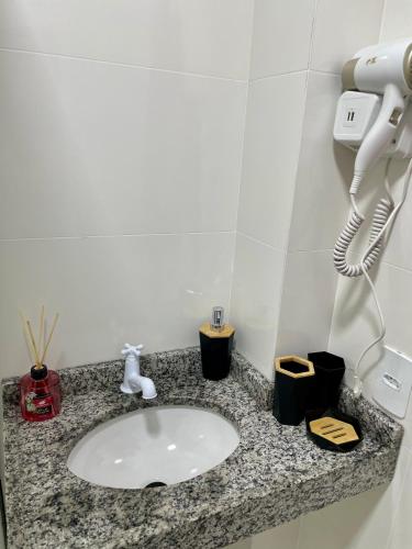 a bathroom counter with a sink and a phone at The Garden 103 - paz e sofisticação - 2 quartos ar condicionado in Cascavel
