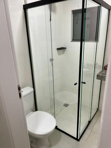 a bathroom with a toilet and a glass shower at The Garden 103 - paz e sofisticação - 2 quartos ar condicionado in Cascavel