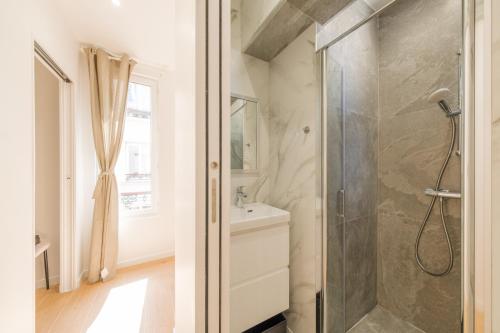une salle de bain avec douche et lavabo dans l'établissement Magic Apartment 4p Sacre Coeur, à Paris
