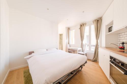 une chambre blanche avec un lit et une cuisine dans l'établissement Magic Apartment 4p Sacre Coeur, à Paris
