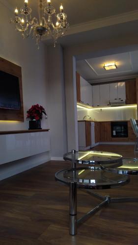 a living room with two glass tables and a chandelier at Comfort Deluxe Kosmos Apartments in Ohrid