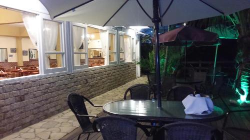 a table and chairs with an umbrella on a patio at Pousada D'amoras in Conservatória