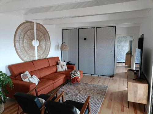 a living room with a brown couch and a tv at Our Place in Pico in Companhia de Cima