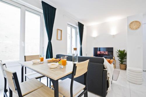 une salle à manger et un salon avec une table et des chaises dans l'établissement Parisien & Cosy, à Paris