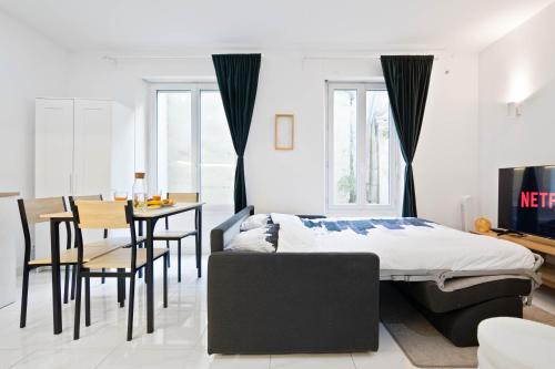 une chambre avec un lit, une table et des chaises dans l'établissement Parisien & Cosy, à Paris