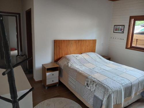 a small bedroom with a bed and a window at Casa Super Astral no Sul da Ilha in Florianópolis