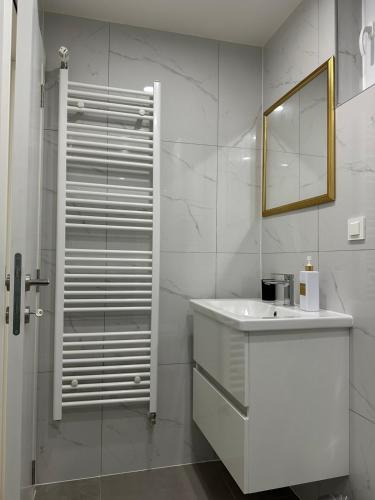 a white bathroom with a sink and a mirror at Cibalae Residence, Self Check-In in Vinkovci