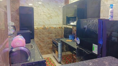 a kitchen with a black refrigerator and a stove at اهلا بيكم في بيتنا in Jazīrat al ‘Awwāmīyah