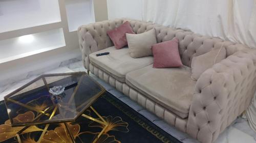 a couch with pillows on it in a living room at اهلا بيكم في بيتنا in Jazīrat al ‘Awwāmīyah