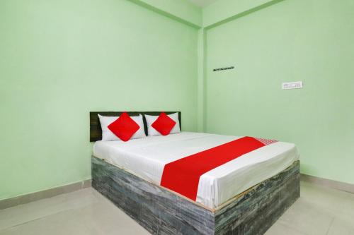 a bedroom with a bed with red pillows on it at Hotel Sunshine in Hyderabad