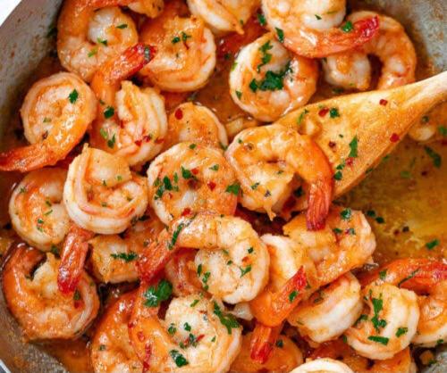 a bowl of shrimp with a wooden spoon in it at Pousada e Restaurante o Portuga in São Miguel dos Milagres