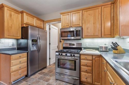 a kitchen with wooden cabinets and stainless steel appliances at Charming Ann Arbor Retreat Near DT & Attractions home in Ann Arbor