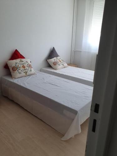 - une chambre avec 2 lits avec des oreillers et une fenêtre dans l'établissement appartement lumineux, à Tours