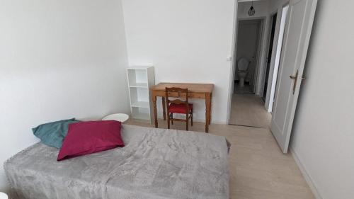 une chambre avec un lit et une table avec une chaise dans l'établissement appartement lumineux, à Tours