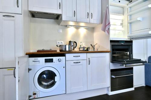 une cuisine blanche avec un lave-linge et un sèche-linge. dans l'établissement Romantic studio in center of Paris, à Paris