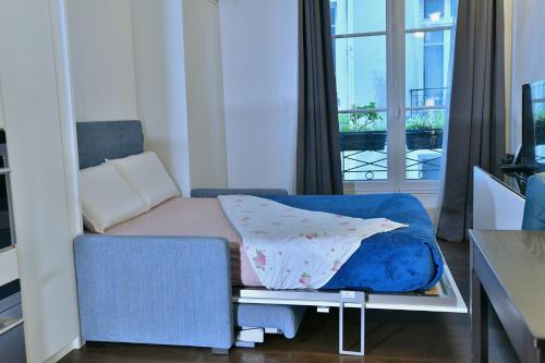 une petite pièce avec un lit et une fenêtre dans l'établissement Romantic studio in center of Paris, à Paris