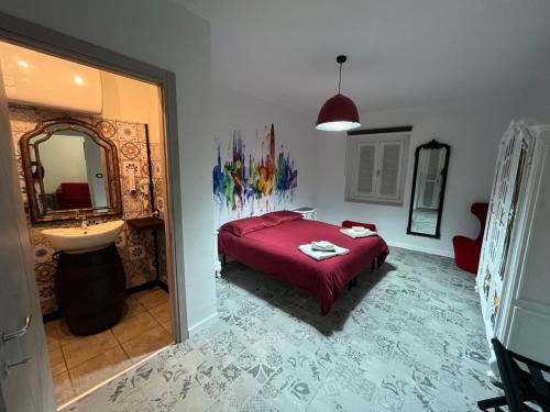 a bedroom with a bed and a sink and a mirror at Estilenuevo Fashion Rooms in Druento