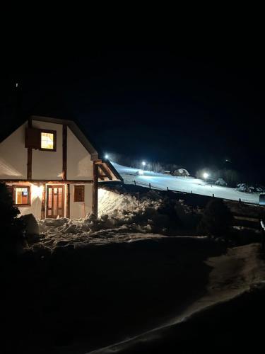 a house in the snow at night at NV Mountain House in Žabljak