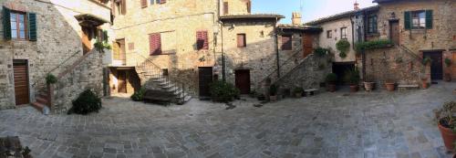 an old stone building with stairs in a courtyard at Borgo San Gusmè in San Gusmè