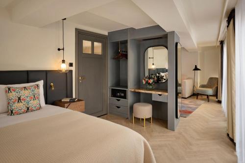 a bedroom with a bed and a desk with a mirror at The Reach at Piccadilly, Manchester, a Tribute Portfolio Hotel in Manchester