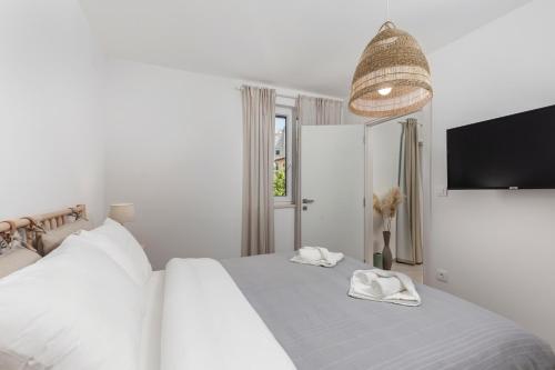 マリンスカにあるApartments by the sea nska, Krk - 23651の白いベッドルーム(ベッドに白いタオル2枚付)