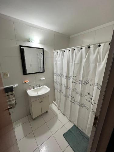 a bathroom with a shower curtain and a sink at Altos Resistencia in Resistencia
