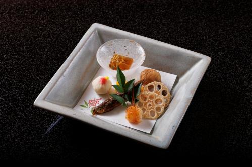 a white plate with food on a table at 四季亭 Shikitei in Nara