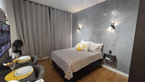 Un dormitorio pequeño con una cama y un escritorio. en Loft Moderno e Aconchegante a Dois Passos da Feirinha do Alto!, en Teresópolis