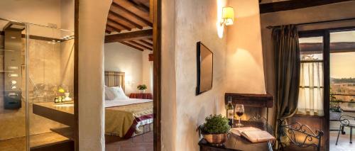 a hotel room with a bed and a balcony at Castello di Spaltenna Exclusive Resort & Spa in Gaiole in Chianti