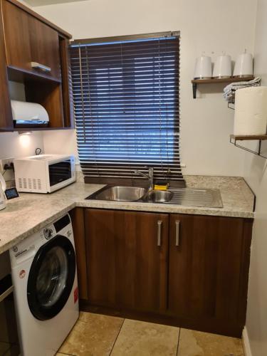 a kitchen with a sink and a washing machine at Rays Lodge 1 in Middlesbrough