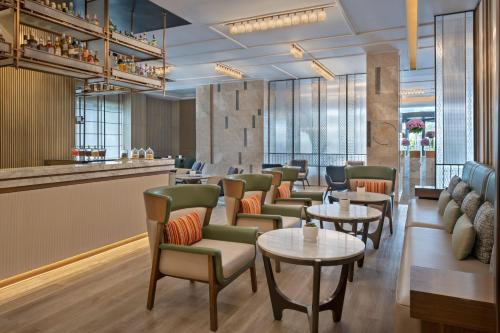 a restaurant with tables and chairs and a bar at Navi Mumbai Marriott in Navi Mumbai