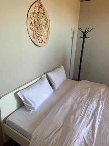 a white bed with two white pillows and a wall at Royal desert camp in Al Raka