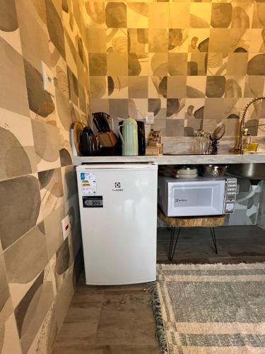 a kitchen with a small refrigerator and a sink at Pousada Alto Colina - Chalé Siriema in Venda Nova do Imigrante