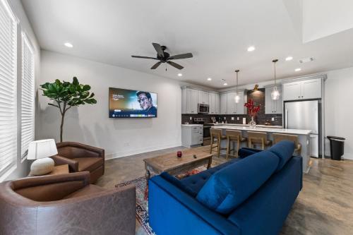 a living room with a blue couch and a kitchen at Basin House 2 King Beds 70in TV Fast WiFi in Lafayette