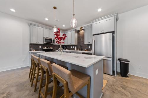 a kitchen with a large kitchen island with chairs at Basin House 2 King Beds 70in TV Fast WiFi in Lafayette