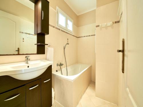 une salle de bain avec un lavabo, une baignoire et des toilettes dans l'établissement Cottage in Corsica with Garden Terrace, à Sari-Solenzara