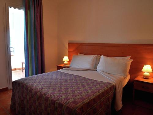 - une chambre avec un lit et 2 lampes sur les tables dans l'établissement Apartment in Moriani-Plage by Sandy Beach, à San-Nicolao