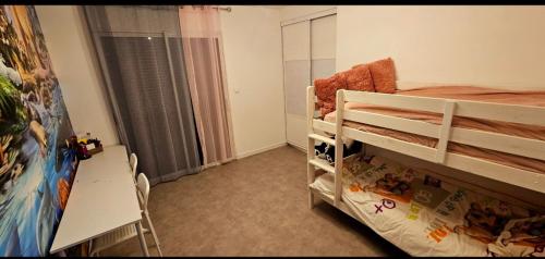 Cette petite chambre comprend des lits superposés et un bureau. dans l'établissement Maison 3 chambres, à Bastelicaccia