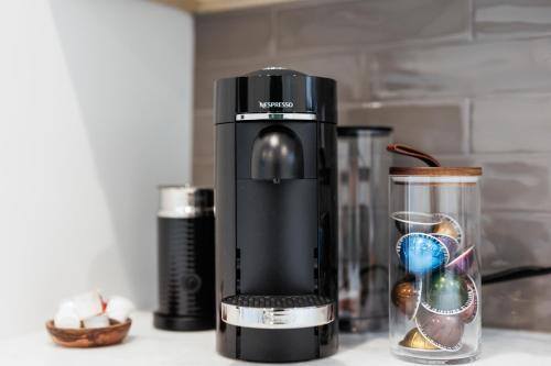 a black juicer sitting on a counter next to a blender at Beignet House Cajun Luxury Full Kitchen Fast WiFi in Lafayette