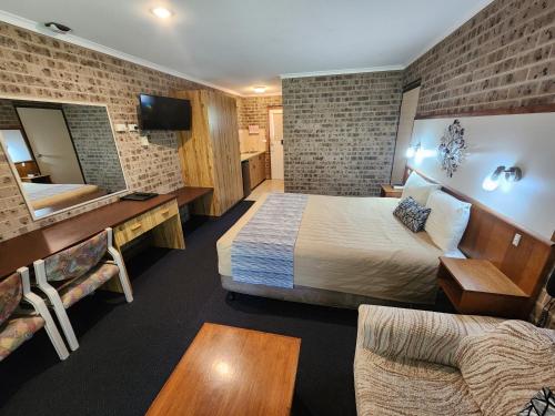 a hotel room with a bed and a mirror at Idlewilde Town & Country Motor Inn in Pambula